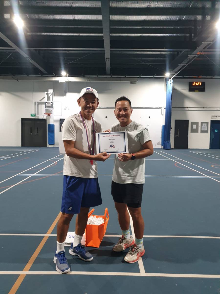 A newly certified pickleball coach receiving a PPR Level 1 certificate