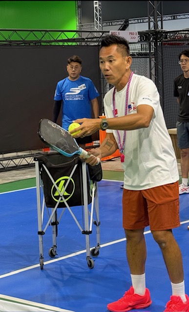 Coach Gary Tan feeding balls from a ball cart during a private pickleball lesson in Singapore